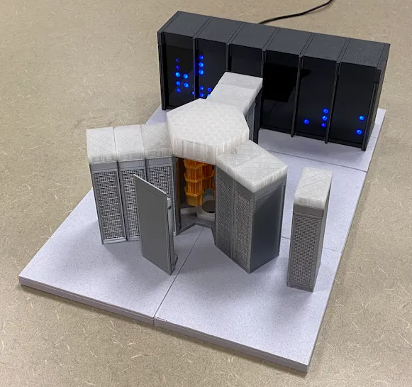 3D-printed models of IBM Quantum System Two and System One with glowing LEDs